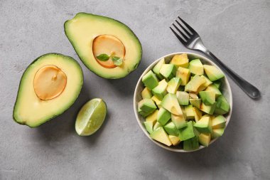 Kompozisyon ile taze olgun avokado gri dokulu arka plan üzerinde kesmek.