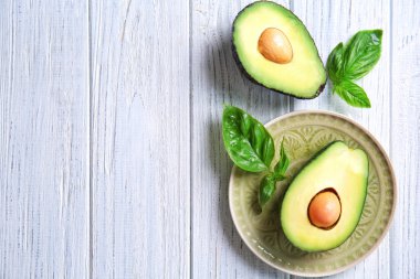 Beyaz ahşap arka plan üzerinde olgunlaşmış avokado kesilmiş taze
