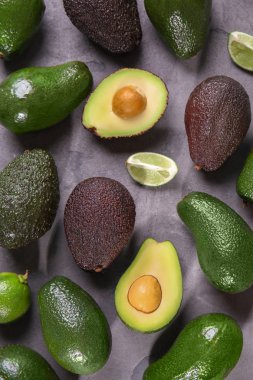 Gri dokulu arka plan üzerinde taze olgun avokado ile kompozisyon