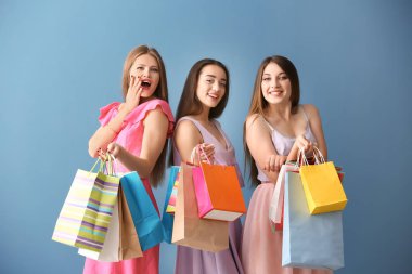 Güzel genç kadınlarla renk arka plan üzerinde alışveriş torbaları