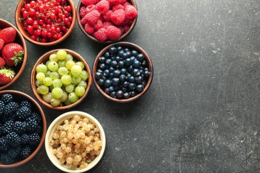 Kase gri arka plan, üstten görünüm üzerinde çeşitli olgun çilek ile