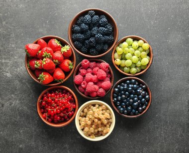 Kase gri arka plan, üstten görünüm üzerinde çeşitli olgun çilek ile