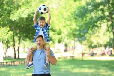 Küçük bir çocuk ve babası ile futbol topu parkta