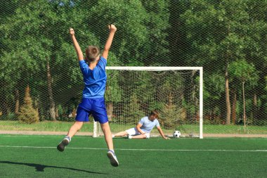 Babasıyla futbol sahada futbol oynarken mutlu çocuk