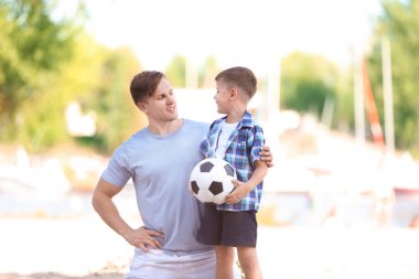 Küçük bir çocuk ve babası ile futbol topu açık havada
