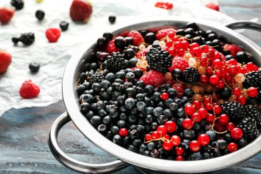 Kevgir ahşap masa üzerinde taze olgun çilek ile