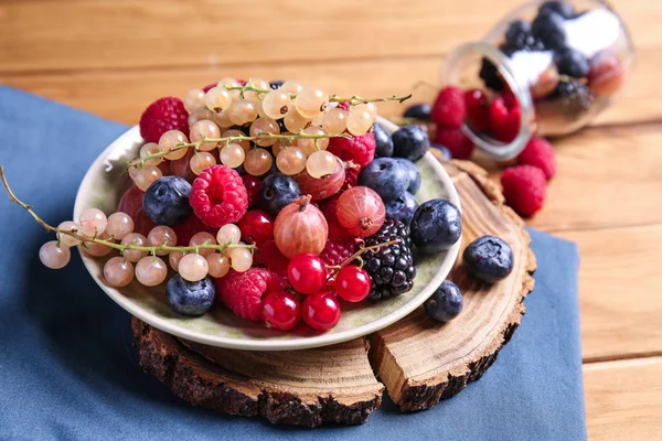 Ahşap masa üzerinde farklı Olgun meyveleri ile plaka