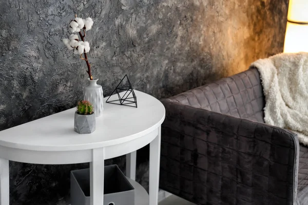 テーブルな花瓶と暗い壁の近くのソファで綿の花支店 — ストック写真