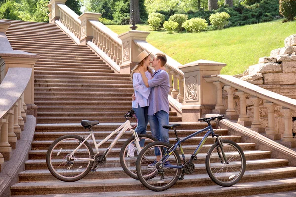Young couple resting after riding bicycles outdoors