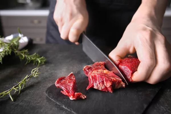 Adam kesme çiğ et mutfak kayrak plaka üzerinde