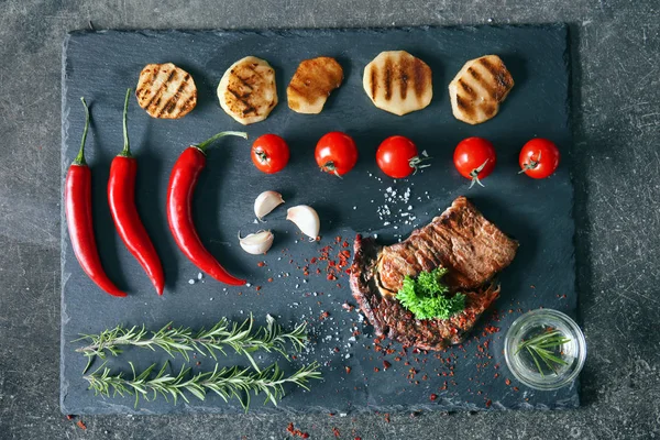 Lezzetli ızgara et, sebze ve otlar kayrak plaka üzerinde kompozisyonu