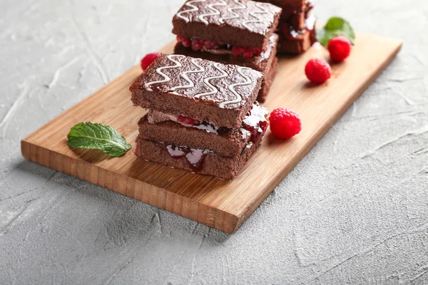 Kurulu ile lezzetli çikolatalı kek ve ışık masada ahududu reçeli