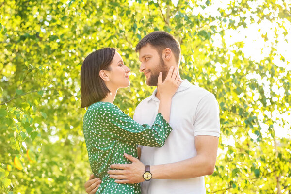 Счастливая прекрасная пара отдыхает в парке в солнечный день
