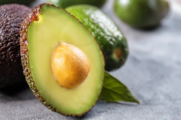 Aguacates Maduros Frescos Sobre Fondo Texturizado Gris — Foto de Stock