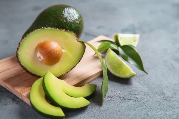 Tablero Madera Con Aguacates Maduros Lima Sobre Fondo Texturizado Gris —  Fotos de Stock