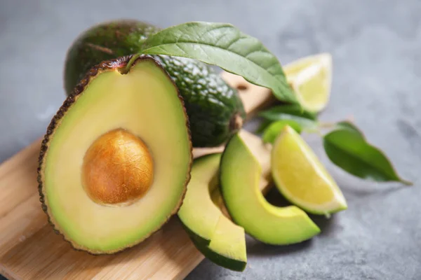 Tablero Madera Con Aguacates Maduros Sobre Fondo Gris —  Fotos de Stock