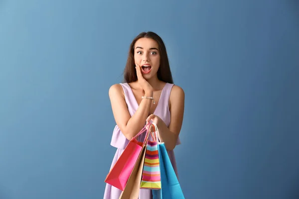 Emotionele Jonge Vrouw Met Boodschappentassen Kleur Achtergrond — Stockfoto