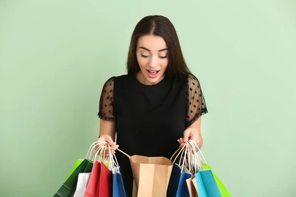 Emotionale Junge Frau Mit Einkaufstaschen Auf Farbigem Hintergrund — Stockfoto