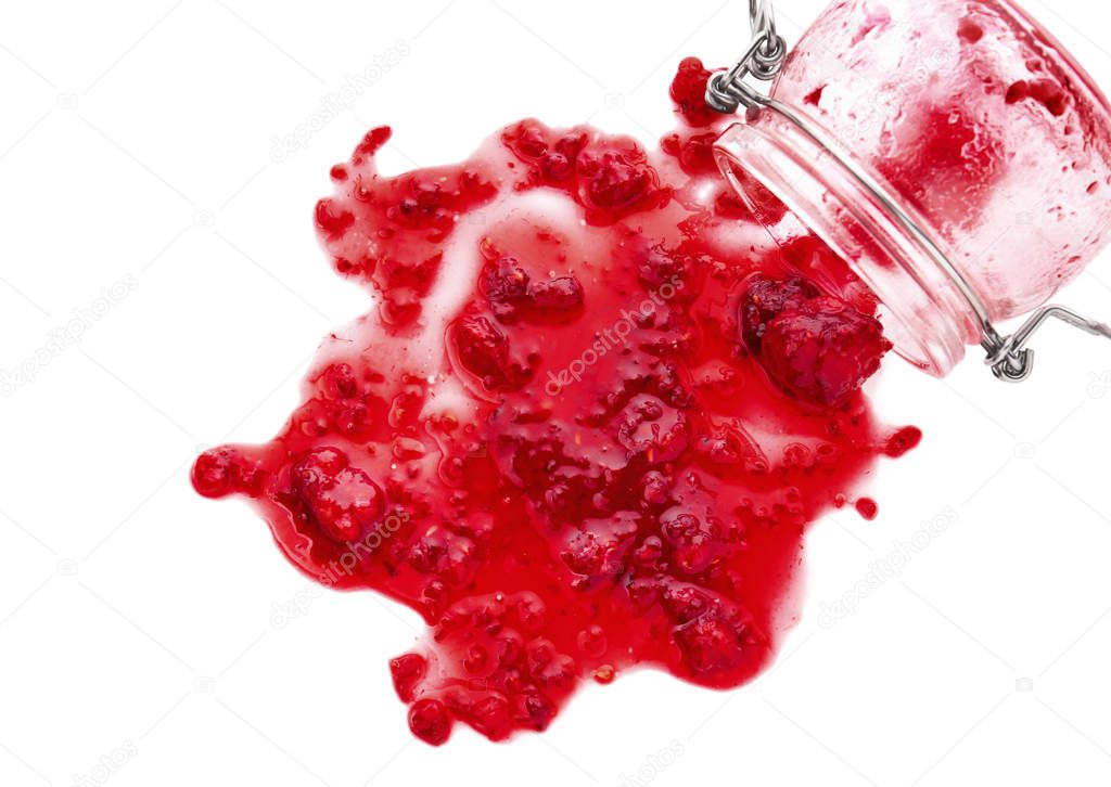 Glass jar and spilled raspberry jam on white background
