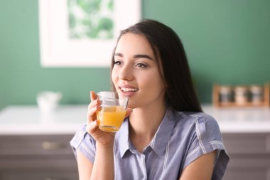 Cam mutfak taze portakal suyu ile genç kadın