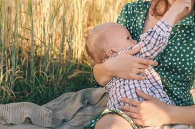 Kadın emzirme açık havada küçük oğlu