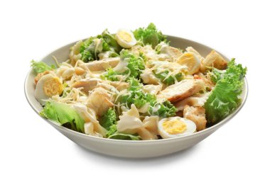 Beyaz zemin üzerinde bir kapta makarna ile lezzetli Sezar salatası