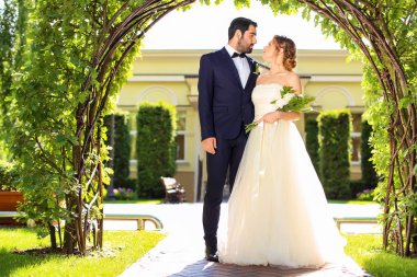 Mutlu evlilik çift çiçek kemerin açık havada altında