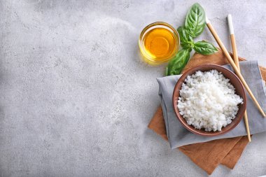 Gri dokulu arka plan üzerinde beyaz haşlanmış pirinç kase