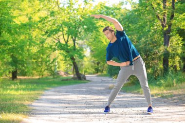 Sportif genç adam parkta eğitim