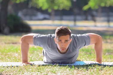 Sportif genç adam dışarıda antrenman yapıyor.