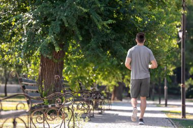 Parkta koşan sportif genç adam
