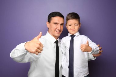 Küçük bir çocuk ve babası gösterilen başparmak-up renk arka plan üzerinde