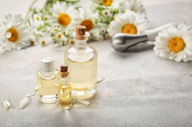 Esans ve masaya papatya çiçek şişe