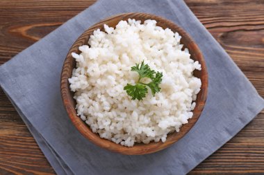 Ahşap masa üzerinde beyaz haşlanmış pirinç kase