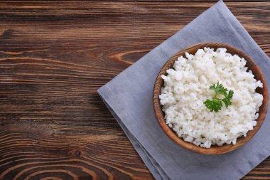 Ahşap masa üzerinde beyaz haşlanmış pirinç kase