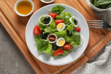 Haşlanmış yumurta ve zeytin ahşap tahta üzerinde lezzetli sebze salatası