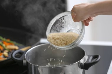 Pirinç kaynar su ile tencereye içine dökme kadın