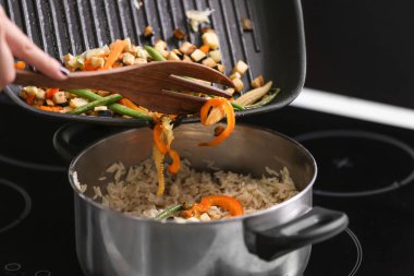 Tencerede haşlanmış pirinç ızgara sebze ekleme