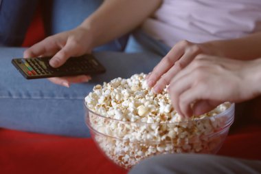 Geceleri, closeup Tv izlerken yemek patlamış mısır genç çift