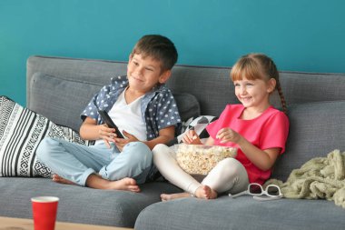 Şirin çocuk evde kanepede televizyon izlerken