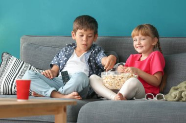 Şirin çocuk evde kanepede televizyon izlerken