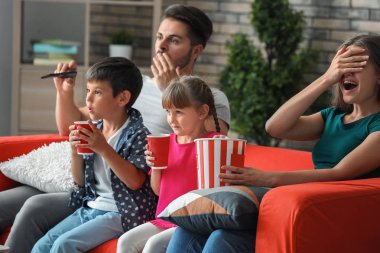 Evde kanepede televizyon izlerken aile