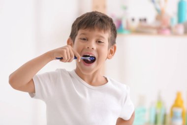 Banyoda dişlerini fırçalayan küçük çocuk.
