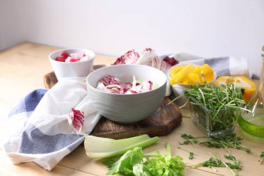 Lezzetli sebze salatası ve malzemelerin üzerine ahşap masa ile kase