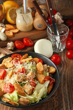 Ahşap masa üzerinde lezzetli Sezar salatası ile plaka