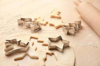 Rulo hamur Noel kurabiyeleri ve ahşap masa üzerinde kesiciler için