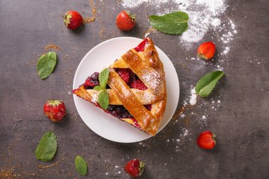 Dilim lezzetli pasta plaka üzerinde çilek ile