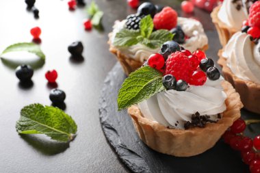 Krem şanti ve kayrak plaka, closeup üzerinde meyveleri lezzetli tartlets
