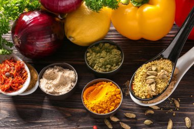 Farklı baharatlar ve sebzeler üzerinde ahşap masa