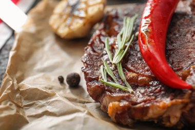 Chili biber ve otlar parşömen, closeup üzerine lezzetli ızgara et